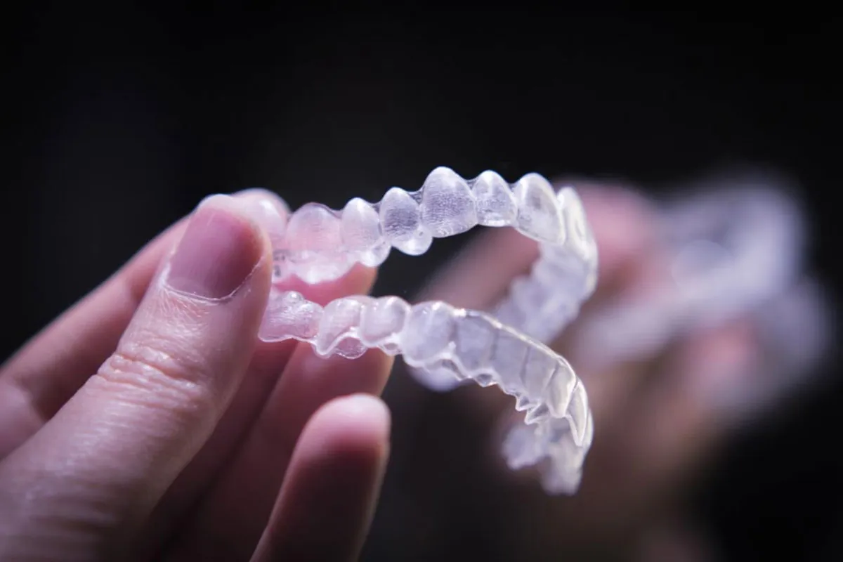 patient holding their new Invisalign clear aligners they got from Desert Dental Spa in Palm Desert, CA